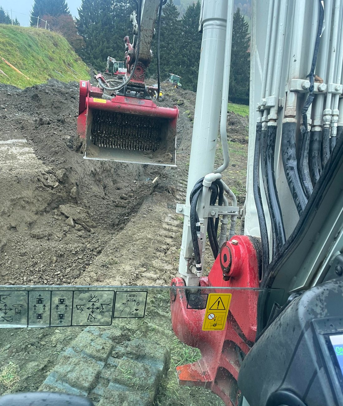 Bagger mit Siebschaufel bei Erdarbeiten