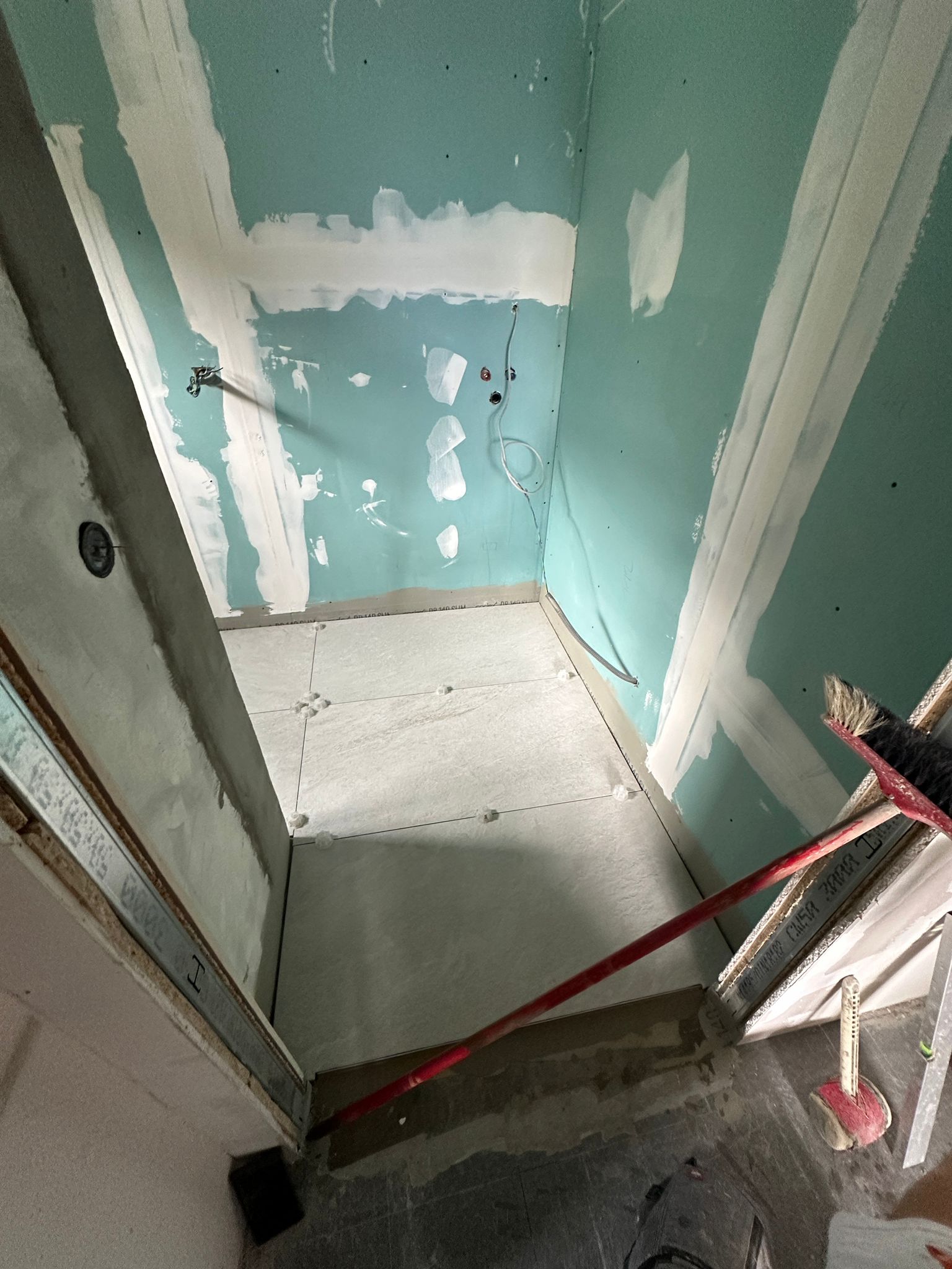 Badumbau mit grünen Trockenbauplatten und Fliesenarbeiten